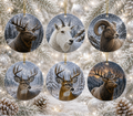 Six round ceramic Christmas ornaments featuring realistic animal portraits of deer, a mountain goat, a bighorn sheep, moose, and elk, in snowy mountain scenes, hanging against a festive snowy tree background with lights and pinecones.